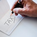 The word "Tax" handwritten on a checkbook register