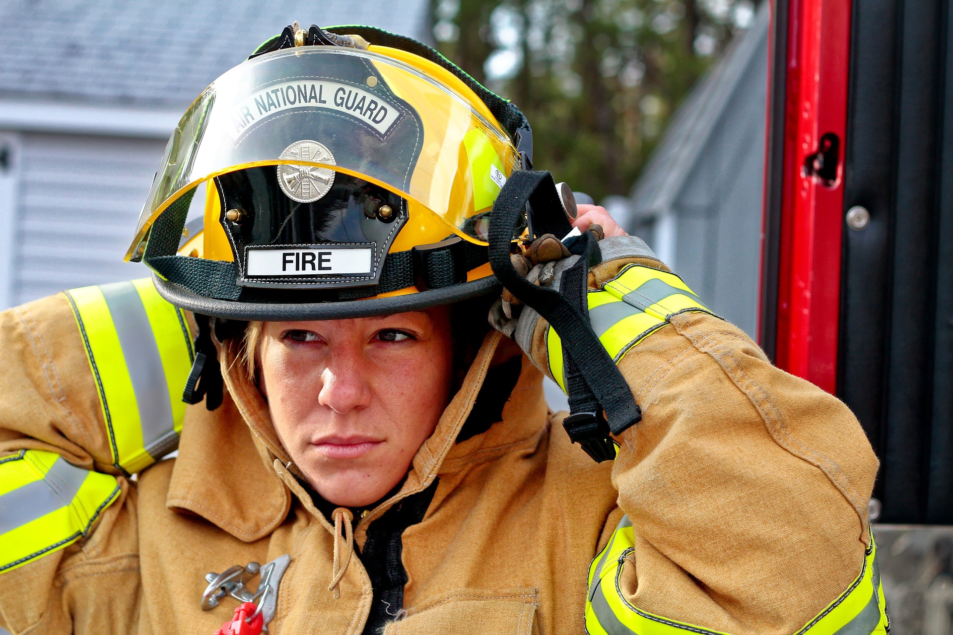 A woman in a firefighter's uniform prepares for duty.